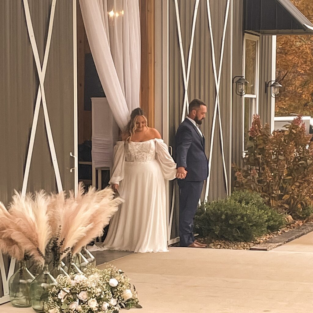 Bride and groom holding hands as they enjoy a first touch at Homestead 32 wedding venue near Knoxville, Chattanooga and Nashville