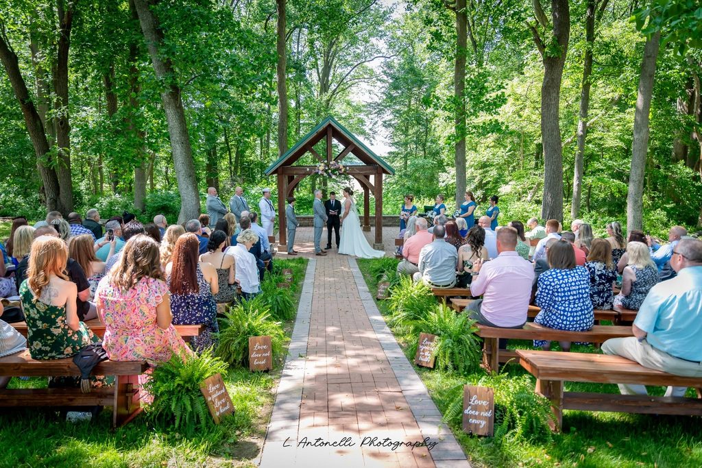 Outdoor wedding ceremony setting surrounded by mature trees in Middletown DE
